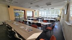 Blick in den Multifunktionsraum mit vielen Tischen und Stühlen