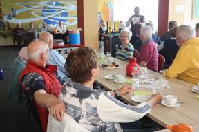 Senioren sitzen an einer Kaffeetafel