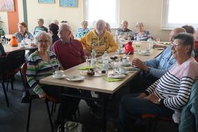 Senioren sitzen an einer Kaffeetafel